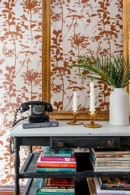 a table with books and a telephone and a mirror at Designer Home, Hot Tub, Private Yard, & Projector in Hudson