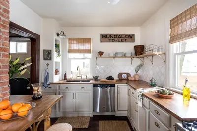 a kitchen with white cabinets and wooden counter tops at Designer Home, Hot Tub, Private Yard, & Projector in Hudson
