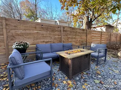 a patio with a couch and two chairs and a table at Designer Home, Hot Tub, Private Yard, & Projector in Hudson
