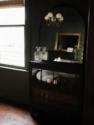 a black cabinet with a mirror and glasses on it at Designer Home, Hot Tub, Private Yard, & Projector in Hudson