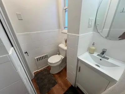 a white bathroom with a toilet and a sink at 7-A Diamond in Yonkers in Yonkers