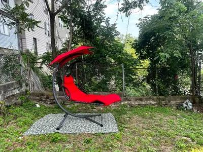 a red swing set in the yard of a house at 7-A Diamond in Yonkers in Yonkers