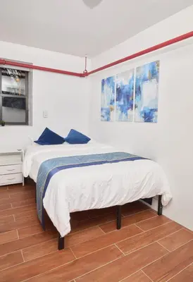 a bedroom with two beds with blue pillows at Comfy Guest House in Hell's Kitchen in New York
