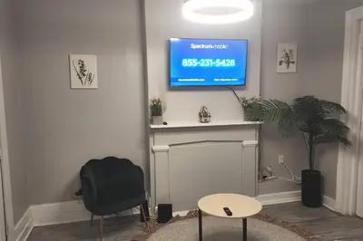 a living room with a tv above a fireplace at Fortune Suits and Apartment in Albany