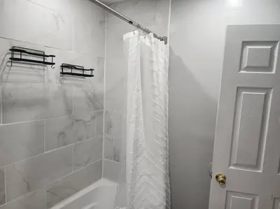 a bathroom with a shower with a shower curtain at Fortune Suits and Apartment in Albany