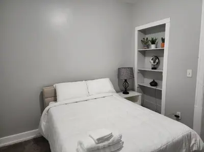 a bedroom with a white bed with towels on it at Fortune Suits and Apartment in Albany