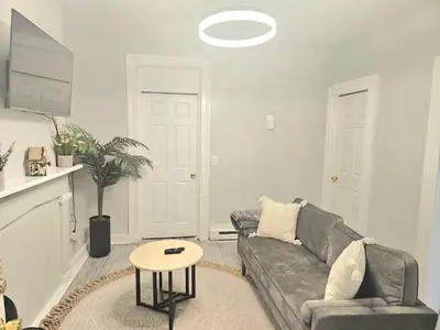 a living room with a couch and a table at Fortune Suits and Apartment in Albany