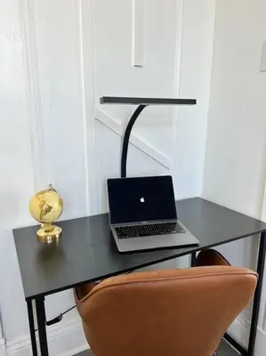 a laptop computer sitting on a black desk with a chair at 1BR Apt 5mins to Proctors in Schenectady