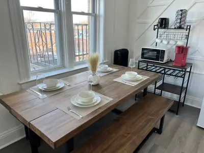 a wooden table with plates and bowls on top of it at 1BR Apt 5mins to Proctors in Schenectady