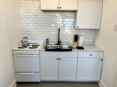 a white kitchen with a sink and a stove at 1BR Apt 5mins to Proctors in Schenectady