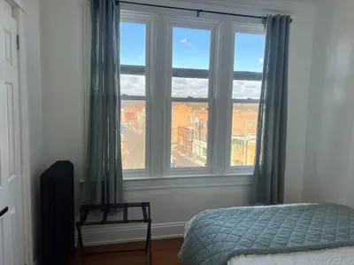 a bedroom with a bed and a large window at 1BR Apt 5mins to Proctors in Schenectady