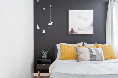 a bedroom with a bed with yellow and white pillows at Game Room+Hot Tub+Pool+King Beds+More in Gansevoort