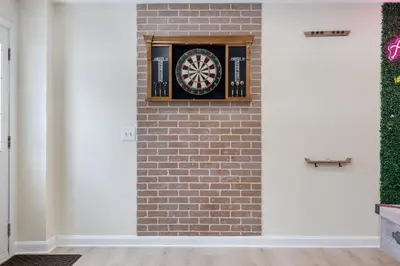 a brick wall with a dartboard on it at Game Room+Hot Tub+Pool+King Beds+More in Gansevoort
