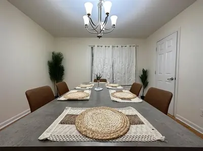 a dining room with a table with chairs and a chandelier at Great Value Close to Proctors Gorgeous Townhouse in Schenectady