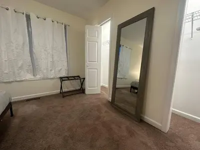 a room with a mirror and a bed and a window at Great Value Close to Proctors Gorgeous Townhouse in Schenectady