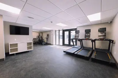 a gym with two tread machines and a flat screen tv at Holiday Inn Express Long Island City E - New York by IHG in Queens