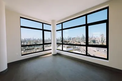an empty room with large windows and a city skyline at Holiday Inn Express Long Island City E - New York by IHG in Queens