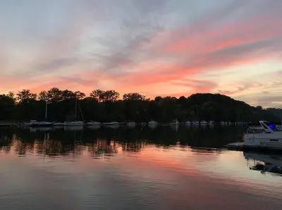 a sunset over a body of water with boats at Beautiful Yacht on Catskill Creek in Catskill