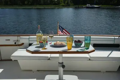 a table on a boat with a plate of food and drinks at Beautiful Yacht on Catskill Creek in Catskill
