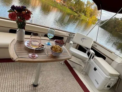 a table with wine glasses and a vase of flowers on a boat at Private Yacht on Catskill Creek in Catskill