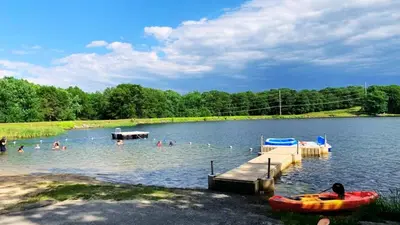 a group of people in the water at a lake at Lakefront, Hot Tub, Heated Pool, Beach, Free Boats in Bushkill