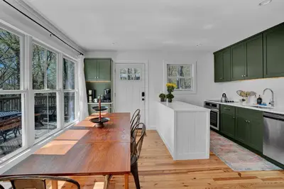 a kitchen with green cabinets and a wooden table at Lakefront, Hot Tub, Heated Pool, Beach, Free Boats in Bushkill