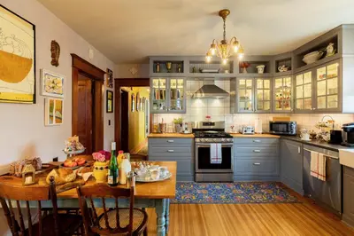 a kitchen with blue cabinets and a wooden table at Palazzo Hudson - Luxury Pool, Hot Tub, and Sauna in Hudson