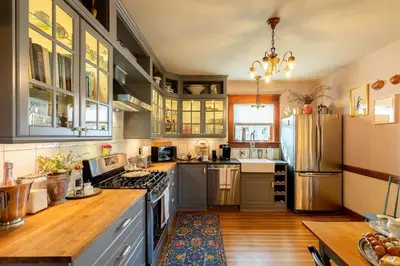 a kitchen with gray cabinets and a refrigerator at Palazzo Hudson - Luxury Pool, Hot Tub, and Sauna in Hudson