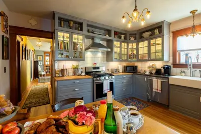 a kitchen with blue cabinets and a table with food on it at Palazzo Hudson - Luxury Pool, Hot Tub, and Sauna in Hudson