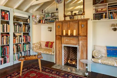 a living room with a fireplace and book shelves at Palazzo Hudson - Luxury Pool, Hot Tub, and Sauna in Hudson