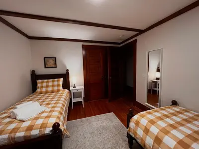 a bedroom with two beds and a mirror at Comfortable and Tranquil -1st Fl in New Haven
