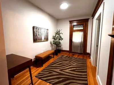 a living room with a table and a rug at Comfortable and Tranquil -1st Fl in New Haven