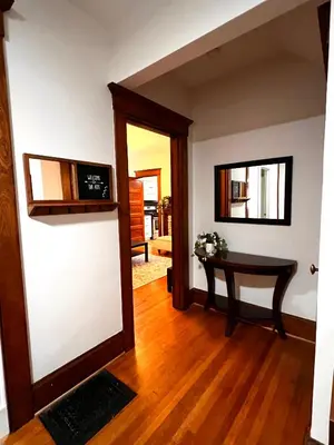 a living room with a table and a mirror at Comfortable and Tranquil -1st Fl in New Haven