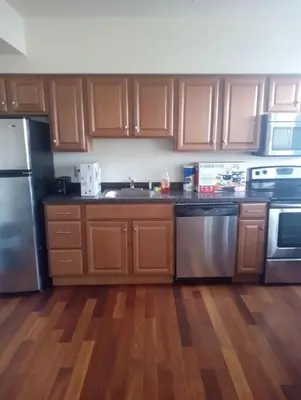 a kitchen with wooden cabinets and stainless steel appliances at 1 bedroom with free parking in Schenectady