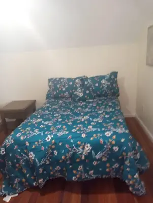 a bed with a blue blanket with flowers on it at a nice one bedroom free parking in Schenectady