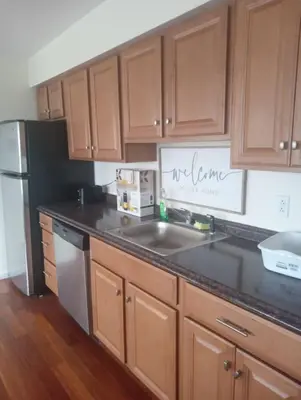 a kitchen with wooden cabinets and a black counter top at a nice one bedroom free parking in Schenectady