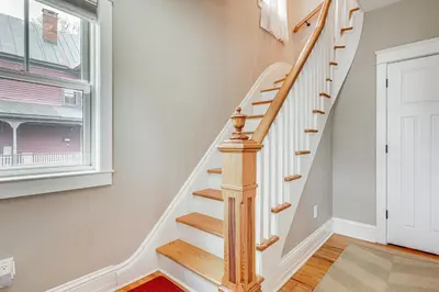 a staircase in a home with white walls and a window at Elegant Saratoga Springs Stay Walk to Town, Track in Saratoga Springs
