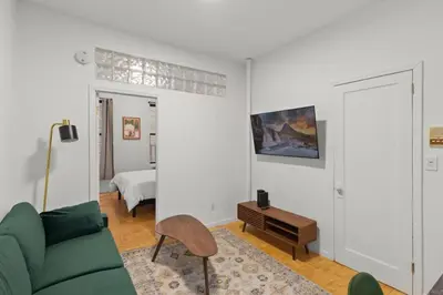 a living room with a green couch and a bed at Cozy 1BR in the Upper East Side in New York