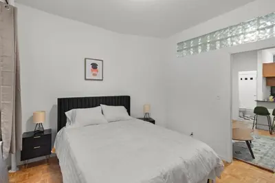 a white bedroom with a bed and a table at Cozy 1BR in the Upper East Side in New York
