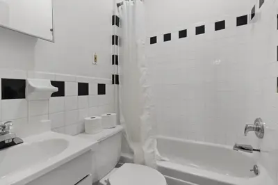a white bathroom with a toilet and a sink at Cozy 1BR in the Upper East Side in New York