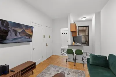 a living room with a couch and two green chairs at Cozy 1BR in the Upper East Side in New York