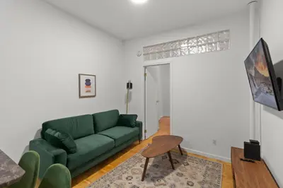 a living room with a green couch and a table at Cozy 1BR in the Upper East Side in New York