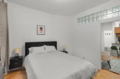 a white bedroom with a bed and a table at Cozy 1BR in the Upper East Side in New York