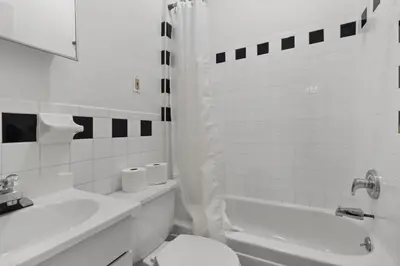 a white bathroom with a toilet and a sink at Cozy 1BR in the Upper East Side in New York
