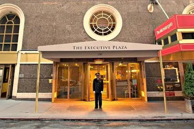 a man in a suit standing in front of a building at PlanURstay - Spacious Midtown West Fully-Serviced - 1BR & 1BTH in New York
