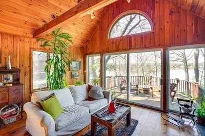 a living room with a couch and some windows at Ski, Sip and Snuggle Cozy Catskills Gem with Views! in Athens