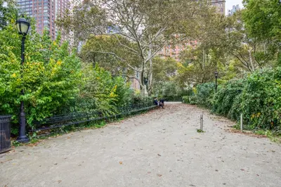 a dirt path in a park with trees and bushes at FiDi 2br w wd doorman elevator roof NYC-772 in New York