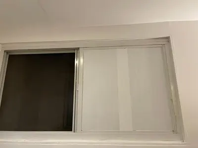 a sliding glass window in a white room at Nest Family Aparthotel - No Window in New York
