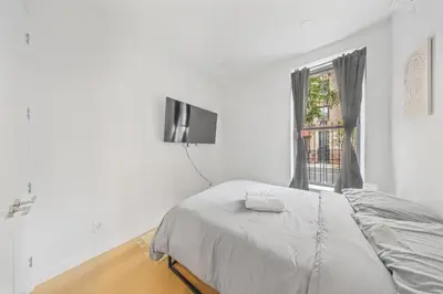 a white bedroom with a bed and a window at Private Room with Shared Bathroom at an Apartment by Times Square in New York