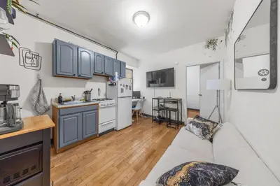 a living room with a couch and a kitchen at Steps from Everything - Modern 1-Bdr in Downtown's Union Square in New York